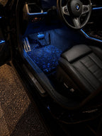 BMW M4 de noche con las alfombrillas de cielo estrellado y la luz de ambiente USB encendidas en azul
