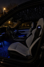 BMW M4 de noche con cielo estrellado en el techo, alfombrillas de cielo estrellado y luces de ambiente encendidas