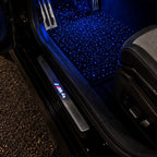 Alfombrillas de cielo estrellado encendidas en azul en un BMW M4 de noche