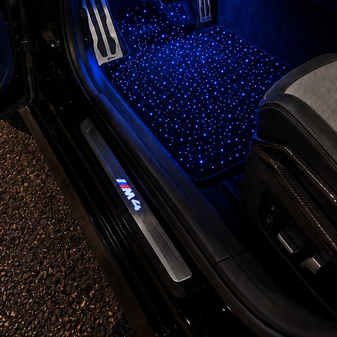 Alfombrillas de cielo estrellado encendidas en azul en un BMW M4 de noche